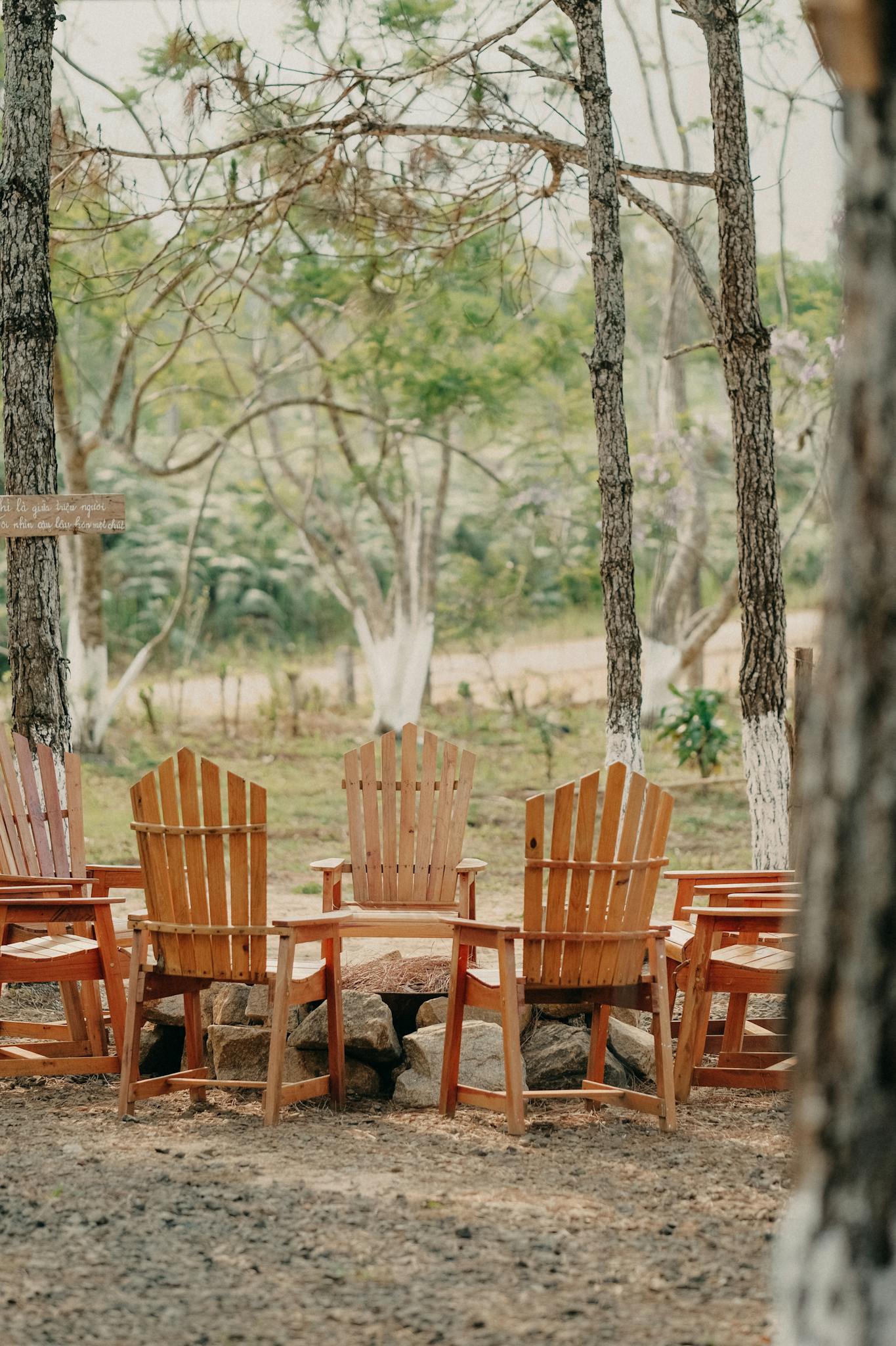 A cozy outdoor seating arrangement with wooden chairs in a serene forest setting.