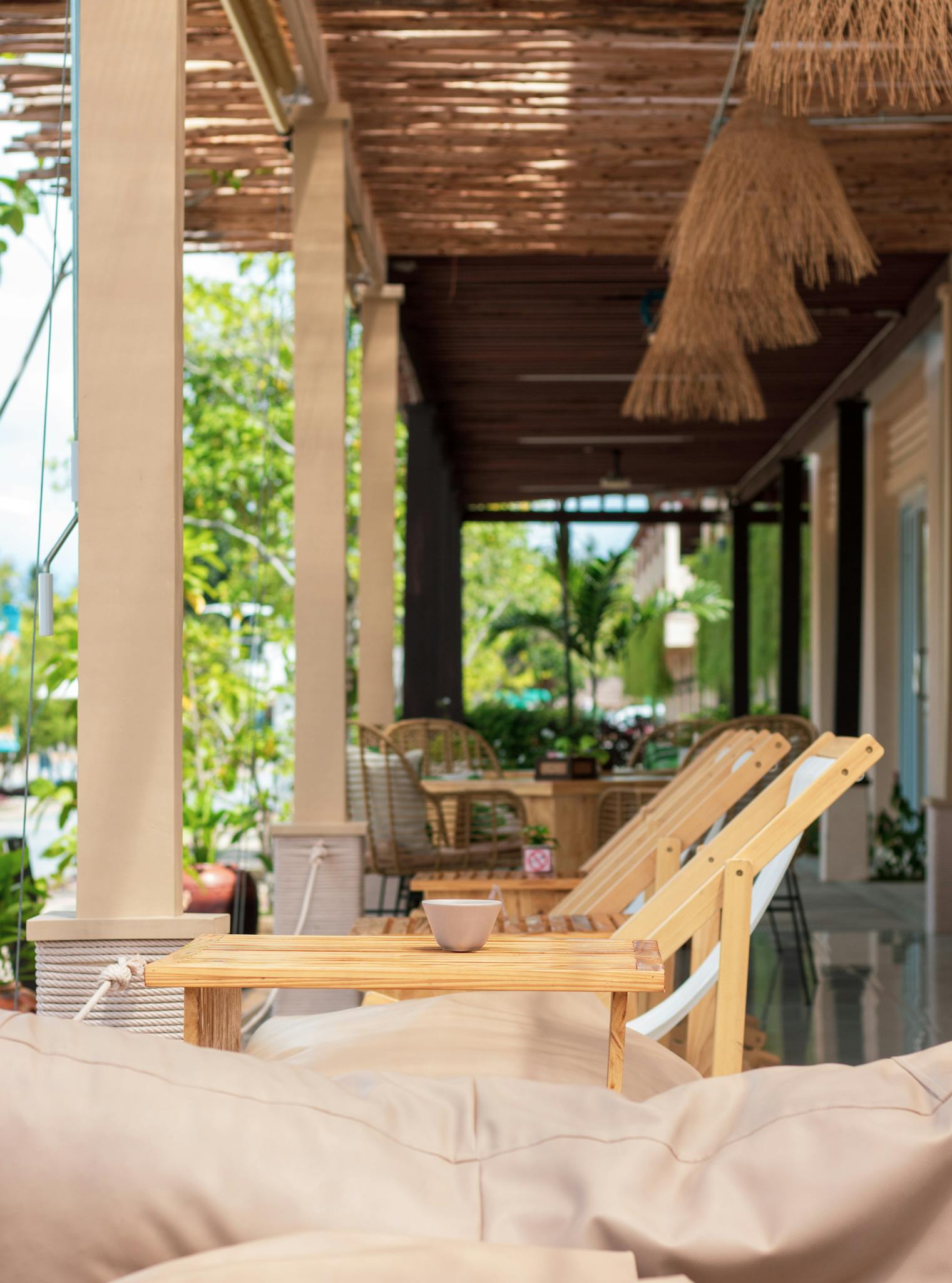 Cozy outdoor patio with wooden furniture and lush greenery, perfect for relaxing and enjoying nature.